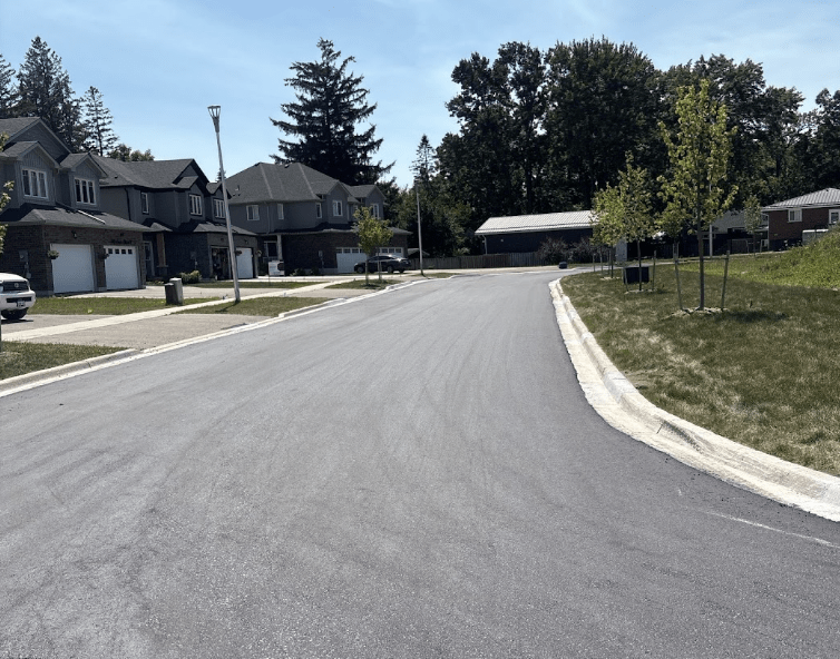 image2 Freshly paved residential roadway with concrete curbs running through a new housing subdivision in Woodstock ON by 5 Star Paving.